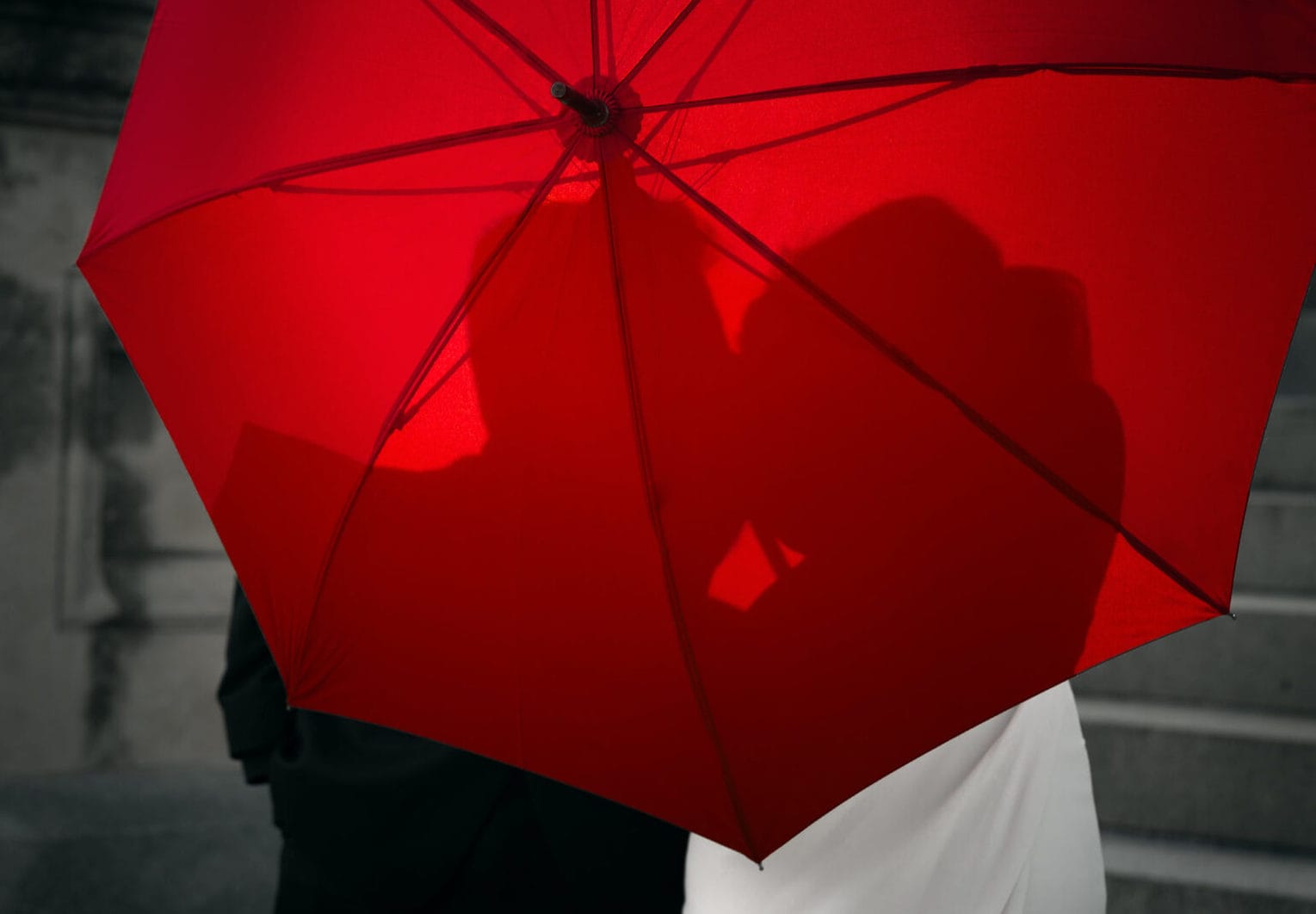 newlyweds Kissing behind umbrella in Kansas